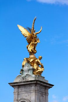 Gilded statue of Goddess of Victory on pinnacle of Queen Victoria Memorial. It's located right in front of Buckingham Palace, London.