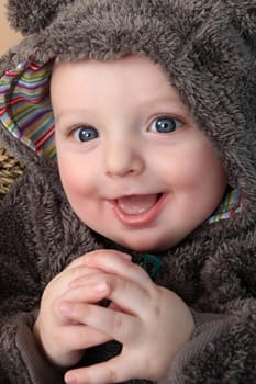 Four month old baby boy wearing a fully bear suit