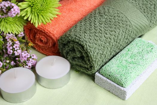 Spa Accessories setting with face cloths, candles and flowers 