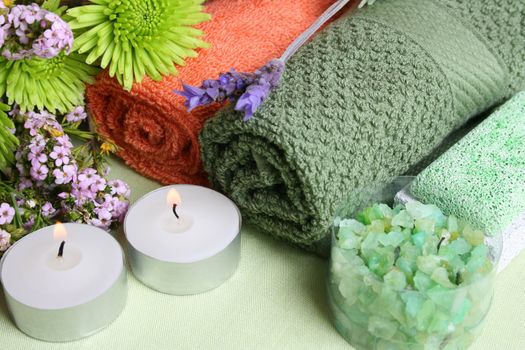 Spa Accessories setting with face cloths, candles and flowers 