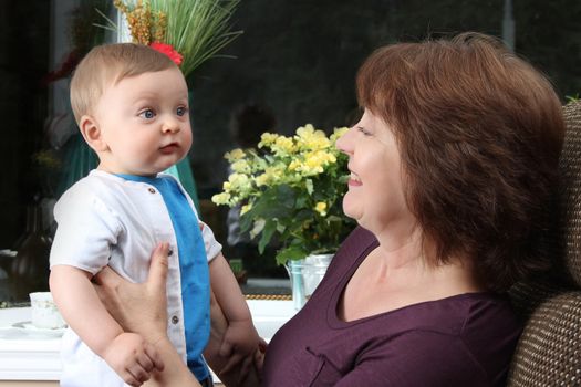 Beautiful baby boy sitting by his grandmother