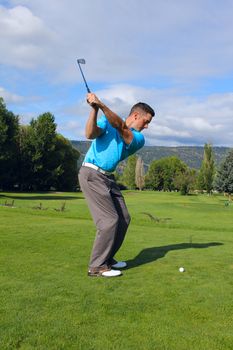 Young golfer hitting a shot with an iron