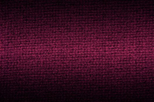 Background a texture a knitted woolen fabric of dark crimson color. horizontal