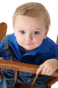 Cute baby boy sitting on a chair looking up