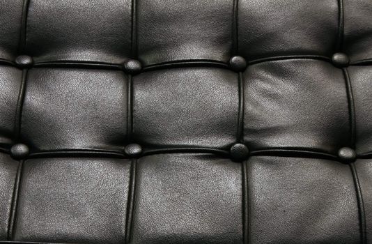 Fragment of a black leather sofa