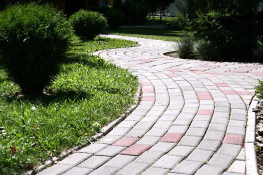 A stone walkway winding its way through a tranquil garden.