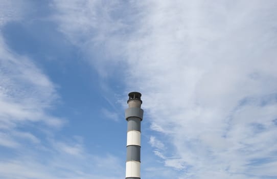 A Black and White Industrial Chimney under a blue sky