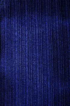 Background a texture a knitted fabric "elastic band" of dark blue color. Vertical