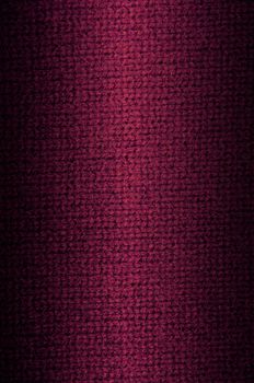 Background a texture a knitted woolen fabric of dark crimson color. Vertical