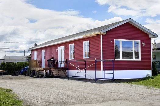 Newly constructed red vinyl siding mobile home at the local trailer park.