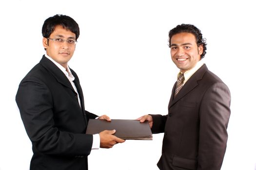 An Indian CEO handing over a file of documents to another CEO, on white studio background.