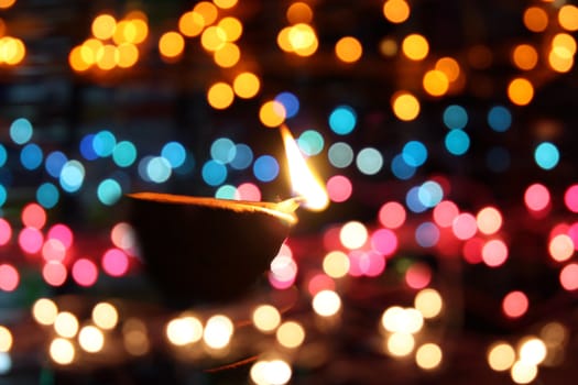 A traditional oil-lamp surrounded by colorful lights, on the occassion of Diwali festival in India.