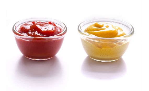 close up of bowls of tomato ketchup and mustard