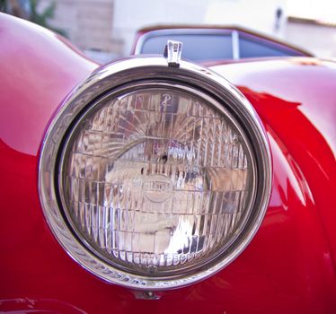 Detail of the metallic red luxury retro sports car.