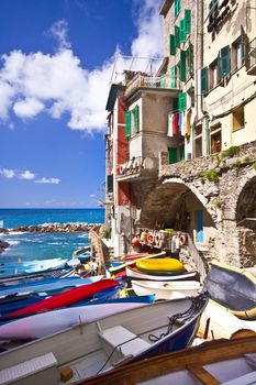 Riomaggiore fisherman village in a dramatic windy weather. Riomaggiore is one of five famous colorful villages of Cinque Terre in Italy, suspended between sea and land on sheer cliffs upon the  turquoise sea.