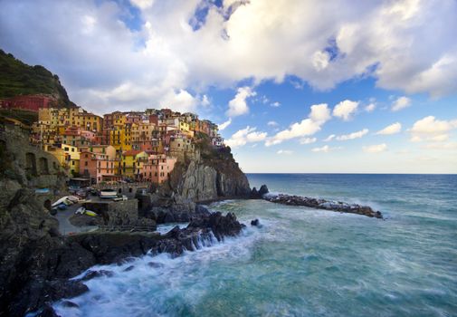 Manarola fisherman village in a dramatic windy weather. Manarola is one of five famous colorful villages of Cinque Terre (Nationa park) in Italy, suspended between sea and land on sheer cliffs upon the wild waves.