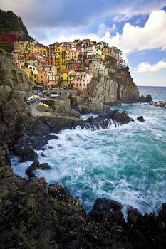 Manarola fisherman village in a dramatic windy weather. Manarola is one of five famous colorful villages of Cinque Terre (Nationa park) in Italy, suspended between sea and land on sheer cliffs upon the wild waves.