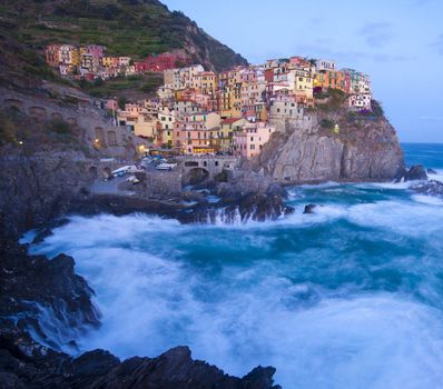 Manarola fisherman village in a dramatic wind storm. Manarola is one of five famous villages of Cinque Terre (Nationa park), suspended between sea and land on sheer cliffs upon the wild waves.