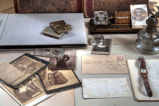 Old photos in sepia,letters,albums,oil-lamp,inkpot and watch.