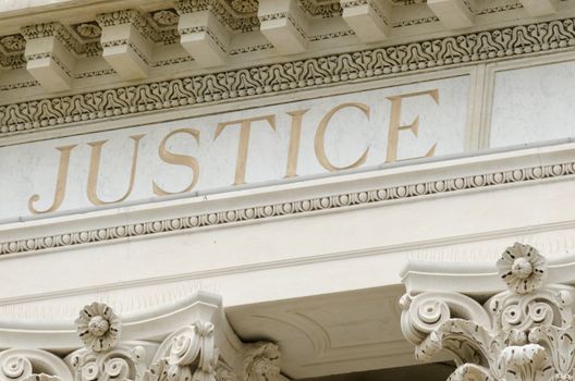 justice word engraved on the pediment of the courthouse