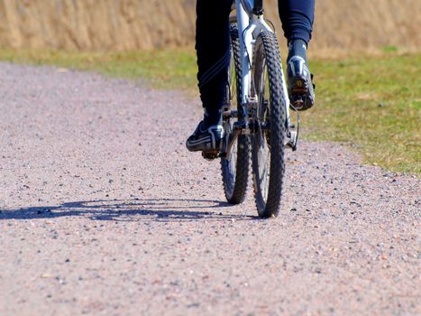 Someone biking on a gravel road