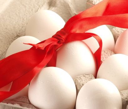 Eggs with red ribbon, in a egg box