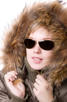 playful girl with sunglasses in a jacket with a collar of fur