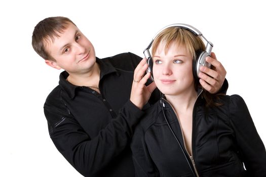 Young happy amorous couple with headphones at home