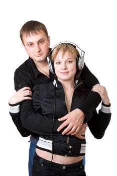 Young happy amorous couple with headphones at home