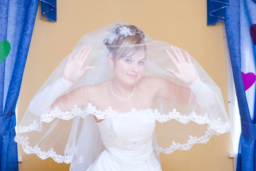 smiling bride looking from the veil