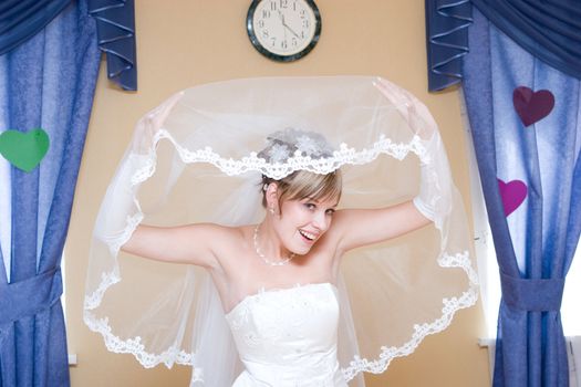 bride at home plays with the veil