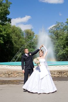 a bride and a groom danse near the fountain