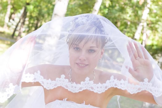 young bride looks through the beautiful veil