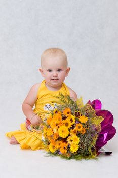 small happy girl with a flower bouquet on the floor