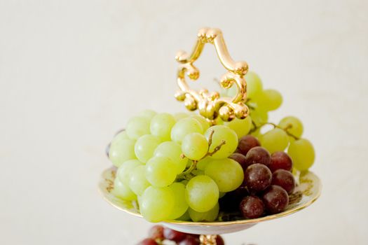 green and red grape on the decorated plate