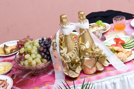 two golden bottles of champagne on the decorated table