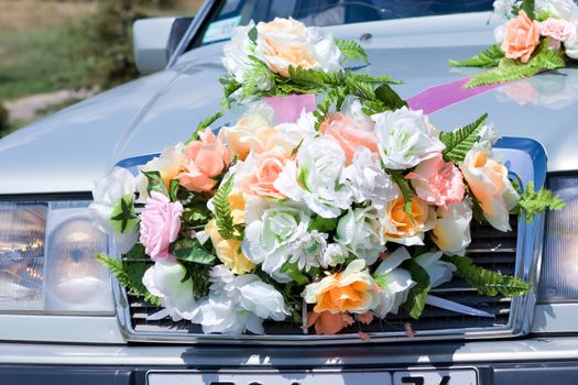 the front part of the car decorated with artificial flowers