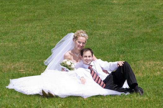 bride and groom together on the green grass