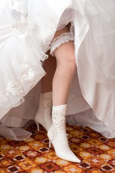 a sexy leg of the bride with garter in a boot