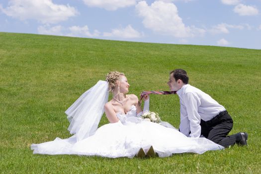 bride playes with necktie of groom