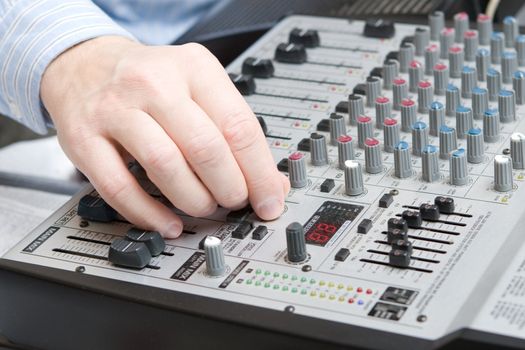 hand adjusts setting on the board of a synthesizer