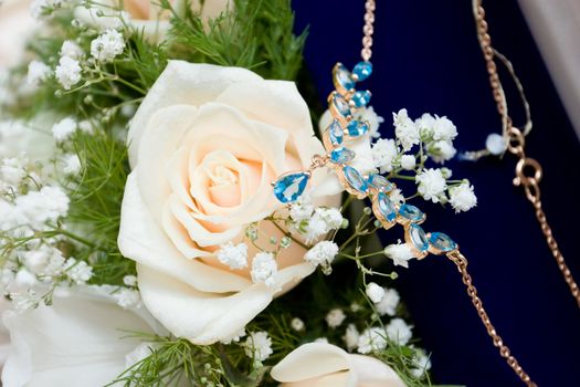 necklace over a white rose wedding bouquet