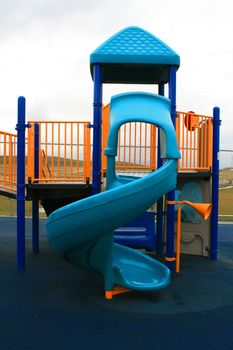 Blue slide in a school playground in a summer.
