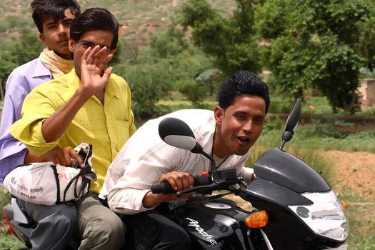 road scene in India - three people on one motorcycle