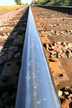 Close up of a rail track going into the horizon.
