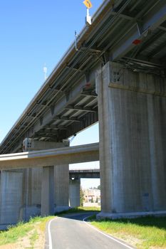 Close up of a road under the freeway ramps.
