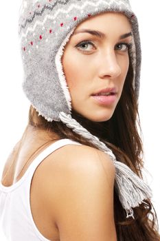 beautiful woman wearing winter cap looking over her shoulder on white background