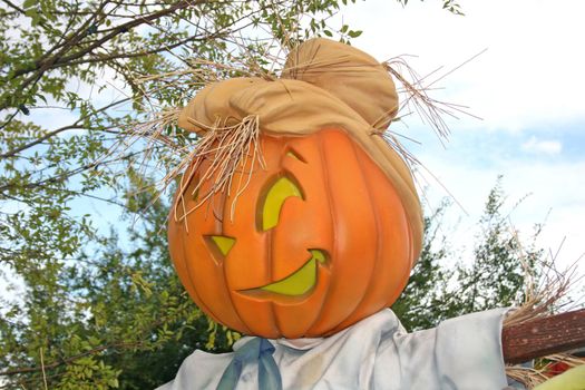 A pumpkin head with a funny face and hat