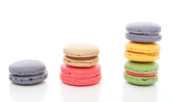 A variety of french macaroons stacked.  White background.