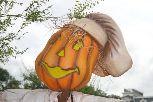 A pumpkin with a funny face and hat